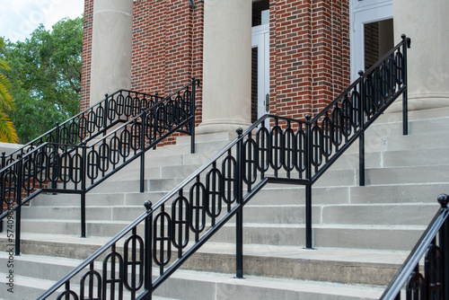 Fotografi Concrete steps lead to multiple doors of a historic building