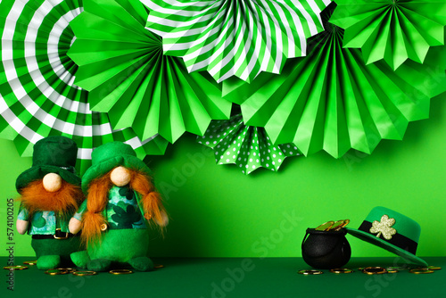 St Patrick s Day holiday banner design. Folding paper fans  leprechauns  hat  clover leaves  pot of gold coins on green table.