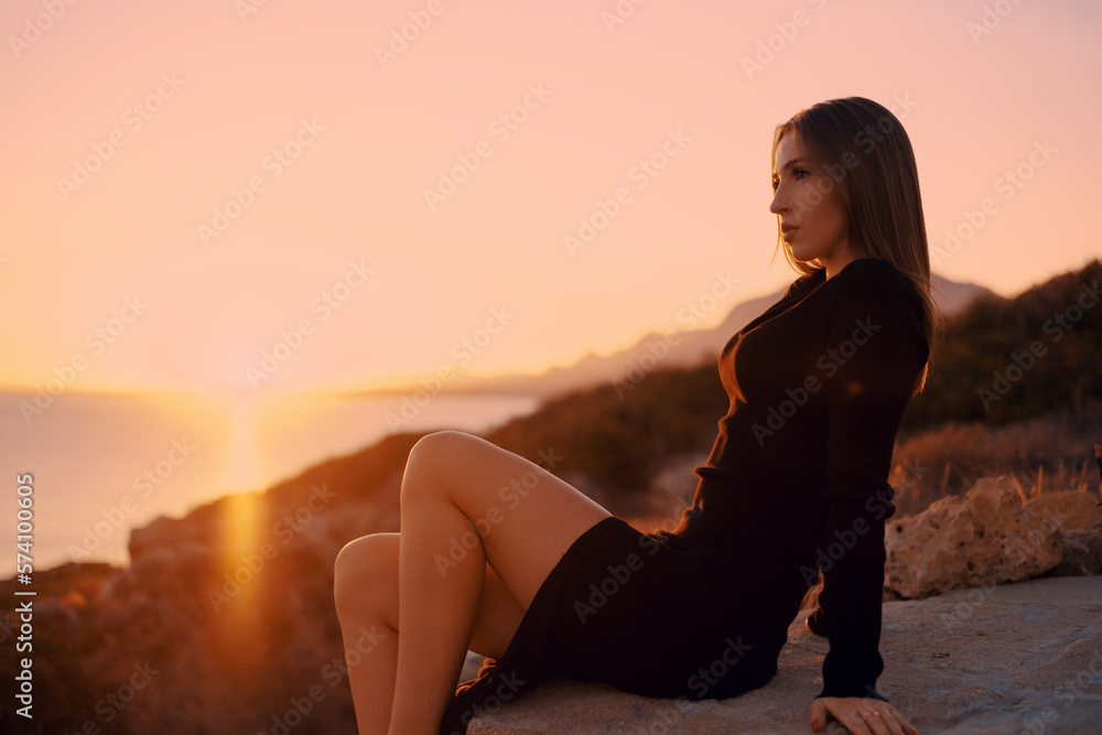 beautiful girl at dawn by the sea and rocks