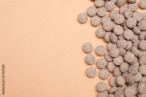 Beer yeast pills on pale orange background, flat lay. Space for text