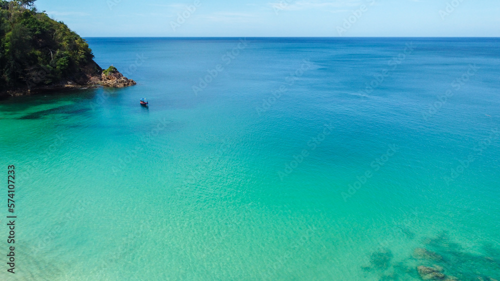 Aerial view of traditional longtail boat approaching a beach, Phuket, Thailand. Beautiful view from above. Turquoise waters of Andaman Sea on sunny day, Southeast Asia. Aerial view of traditional longtail boat approaching a beach, Phuket, Thailand. Beautiful view from above. Turquoise waters of Andaman Sea on sunny day, Southeast Asia.