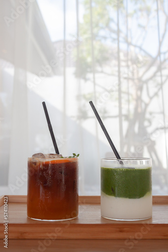 Iced americano with orange and iced matcha green tea in coffee shop photo