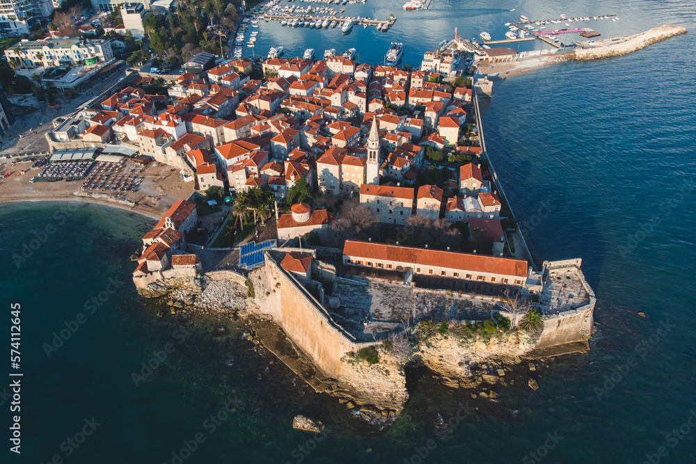 View of Budva old town, Budva Municipality and Riviera, resort on the Adriatic sea coast, Montenegro, sunny day with a blue sky, aerial drone view with beach and mountains, travel to Montenegro