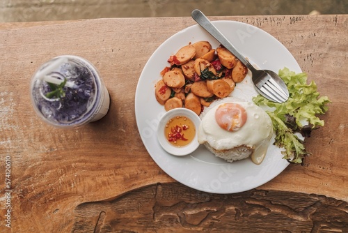 Thai Rice topped with stir-fried sausages and basil with fried egg.