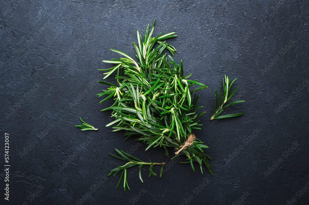 Fresh rosemary bunch on black stone table background. Spices for cooking Top view Fresh rosemary bunch on black stone table background. Spices for cooking Top view