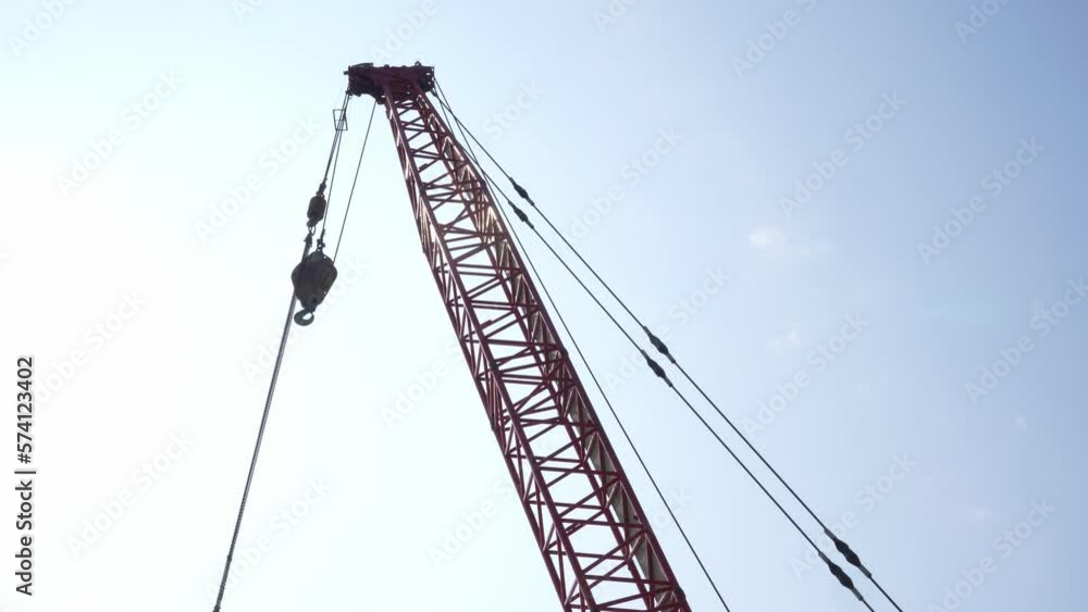 Looking At At Construction Jib Section With Hanging Trolley and Hook Against Clear Sunny Skies Looking At At Construction Jib Section With Hanging Trolley and Hook Against Clear Sunny Skies