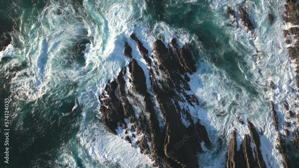 Ocean waves on rocky coast, top down aerial drone view of rough sea water surface Ocean waves on rocky coast, top down aerial drone view of rough sea water surface