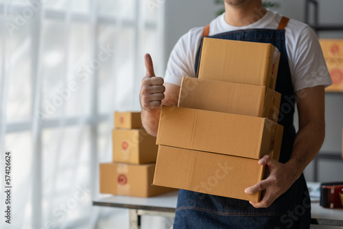 Small Business Startup Owner Asian Independent Entrepreneur Arranging multiple parcel boxes on online orders for delivery arrangements to customers, SME business concept.