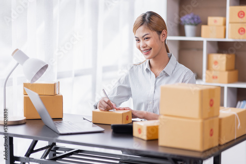 Portrait of Starting Asian female small businesses owners SME entrepreneur working at home, online marketing, packing boxes, SME sellers, concept, e-commerce team, online sales. 