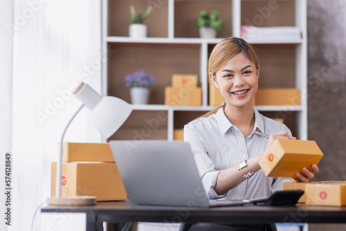 Portrait of Starting Asian female small businesses owners SME entrepreneur working at home, online marketing, packing boxes, SME sellers, concept, e-commerce team, online sales. 