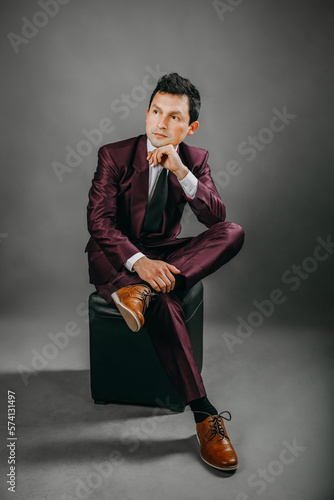 Hombre con traje en estudio con fondo plomo