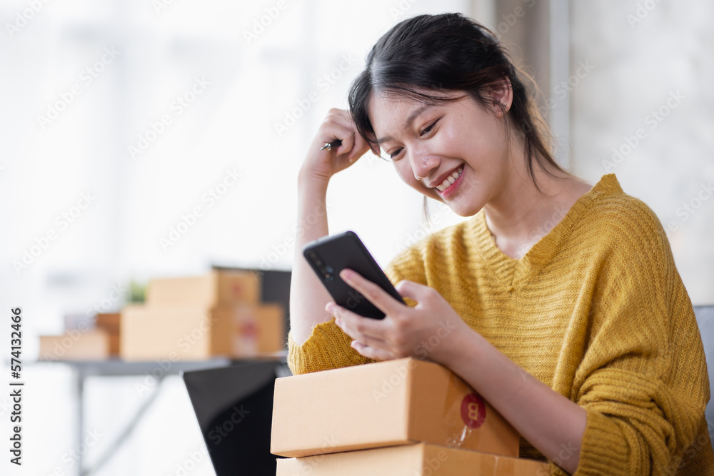 Portrait of Online business owner Asian female small businesses SME entrepreneur working at home, online marketing, packing boxes, SME sellers, concept, e-commerce team, online sales. Portrait of Online business owner Asian female small businesses SME entrepreneur working at home, online marketing, packing boxes, SME sellers, concept, e-commerce team, online sales.