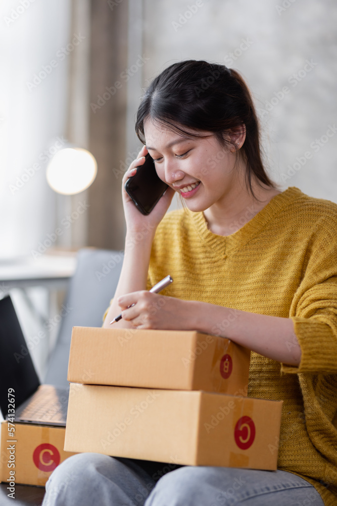 Portrait of Online business owner Asian female small businesses SME entrepreneur working at home, online marketing, packing boxes, SME sellers, concept, e-commerce team, online sales. Portrait of Online business owner Asian female small businesses SME entrepreneur working at home, online marketing, packing boxes, SME sellers, concept, e-commerce team, online sales.