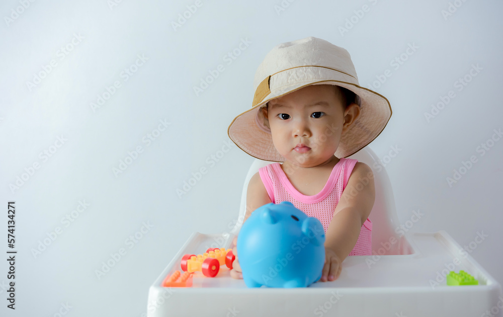Baby boy inserting a coin into a piggybank on white background - financial concept Baby boy inserting a coin into a piggybank on white background - financial concept