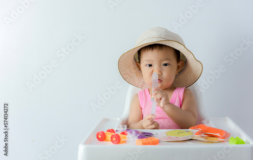 baby cleaning nose by syringe on white background