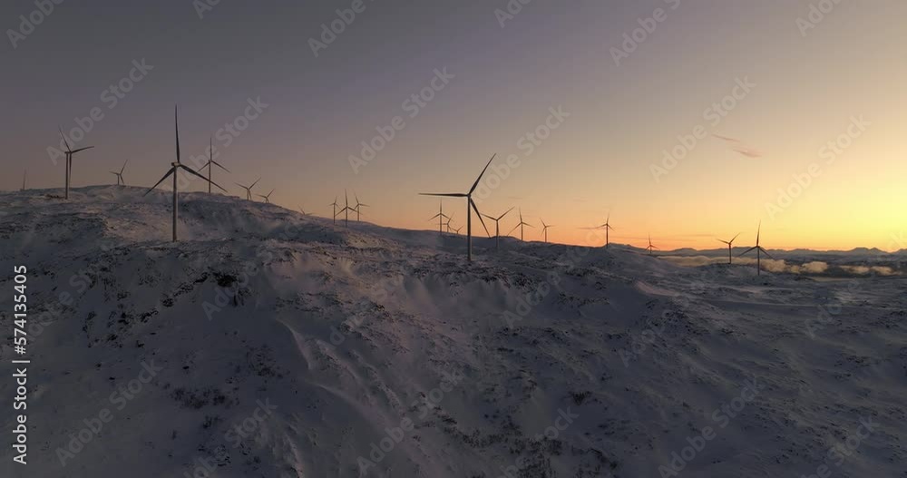 Spinning wind turbines against vivid sunset sky atop snowy mountain, Kvaloya Spinning wind turbines against vivid sunset sky atop snowy mountain, Kvaloya