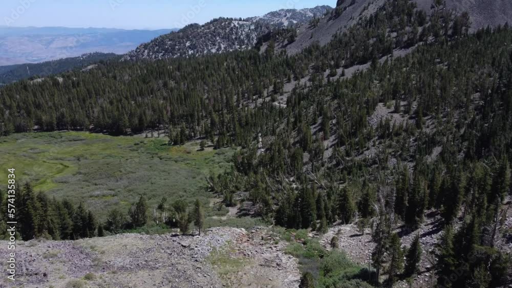 Overhead shot revealing hikers walking out of the forest into a clearing in the Sierra Nevada Mountains. This beautiful nature shot was filmed over a small waterfall using a DJI drone. Overhead shot revealing hikers walking out of the forest into a clearing in the Sierra Nevada Mountains. This beautiful nature shot was filmed over a small waterfall using a DJI drone.