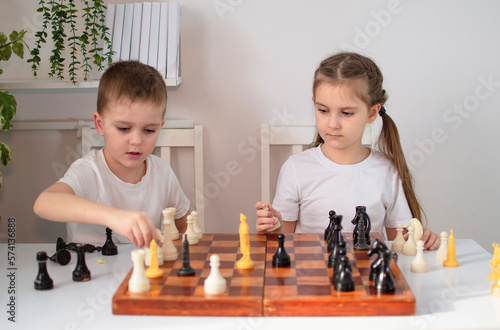 girl is playing chess with her brother at home. Children play board games. Toys for elementary school or kindergarten. Concept of child development. Selective focus