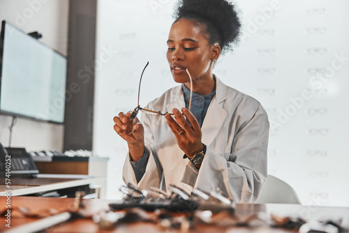 Optometry, repair and optometrist fixing glasses for prescription frame in the optic clinic. Healthcare, vision and African female optician doing maintenance on eyewear or spectacles in optical store