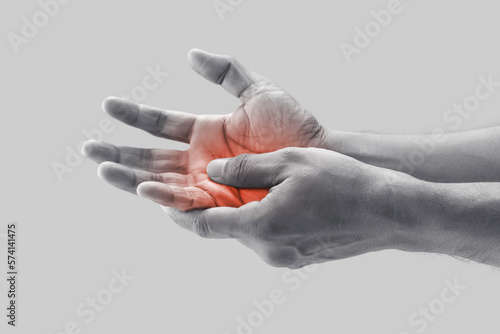 A man grab hand palm because the hand palm was injured. Hand pain. On a gray background. photo