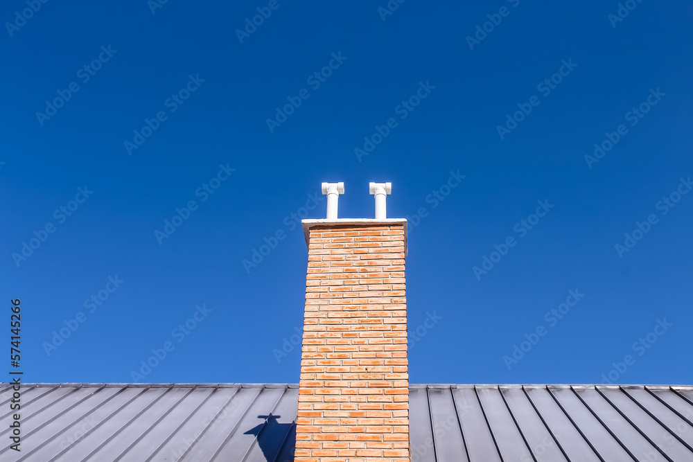 Chimney on the roof  , bright blue sky background
