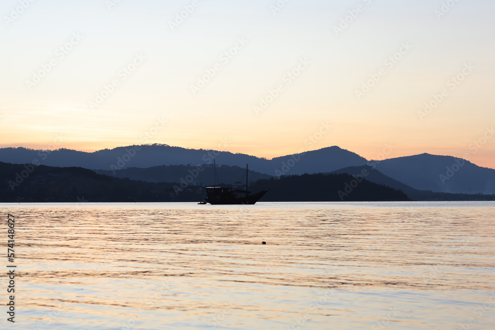 Stunning panoramic view of bay against mountains on horizon with beautiful sunset
