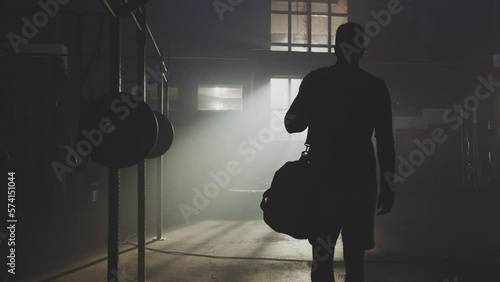 Back view of a confident man coming to the gym with his bag for workout. Sport and fitness concept photo