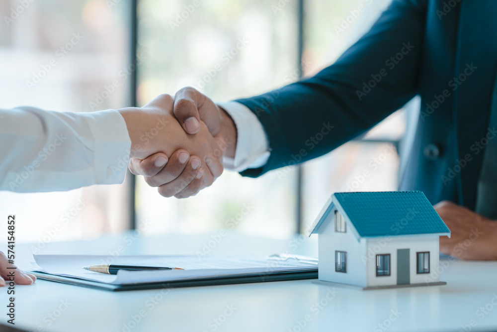 Shaking hands after sign a contract, realtor suggestion a new house model assisting client to sign contract agreement with insurance to happy living building, concerning mortgage loan offer Shaking hands after sign a contract, realtor suggestion a new house model assisting client to sign contract agreement with insurance to happy living building, concerning mortgage loan offer