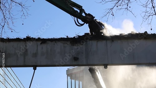 Demolition crane picking apart parts of a building. photo