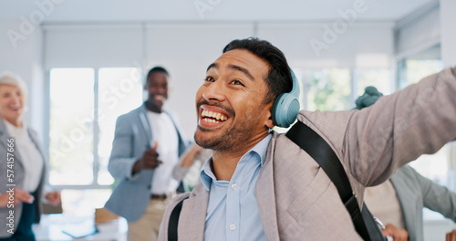 Music, dance and motivation with a business man walking in an office while feeling positive or carefree. Success, happy or smile with a happy male employee arriving at work in headphones with a smile © Nicholas F/peopleimages.com