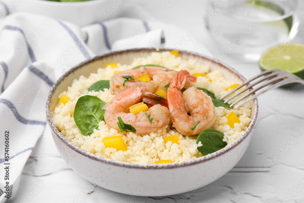 Tasty couscous with shrimps, bell pepper and basil on white textured table, closeup Tasty couscous with shrimps, bell pepper and basil on white textured table, closeup