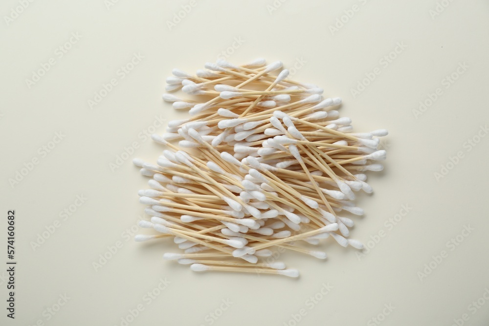 Heap of wooden cotton buds on beige background, flat lay Heap of wooden cotton buds on beige background, flat lay
