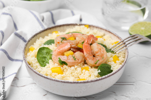 Tasty couscous with shrimps, bell pepper and basil on white textured table, closeup