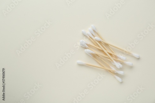 Heap of wooden cotton buds on beige background  flat lay. Space for text