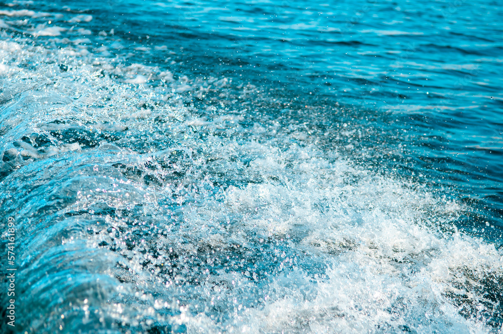 Waves on the sandy beach. Water background, blue sea water. Beautiful texture of sun glare on the water and sea foam. Waves on the sandy beach. Water background, blue sea water. Beautiful texture of sun glare on the water and sea foam.