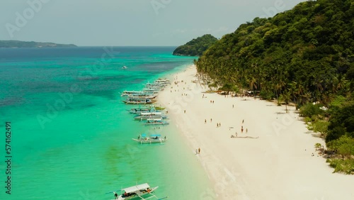 Tropical white sand beach, near the blue lagoon and corall reef from above, Boracay, Philippines. Sandy beach with tourists. Summer and travel vacation concept. photo