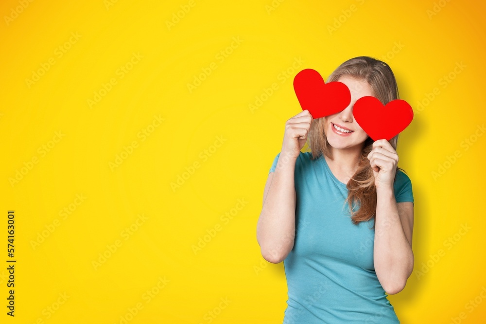 Young woman holding heart-shaped paper Young woman holding heart-shaped paper