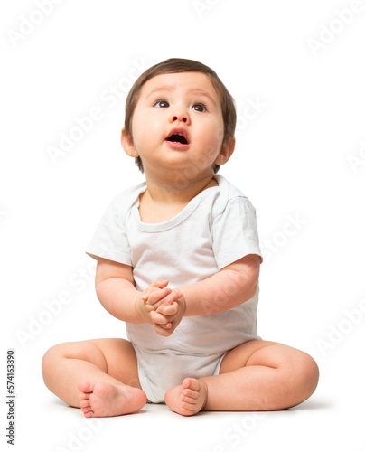 Cute baby looking up in white onesie on white background
