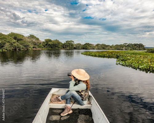 Turista não identificada fotografando animais em passeio de barco no no Pantanal de Barão de Melgaço, Mato Grosso photo