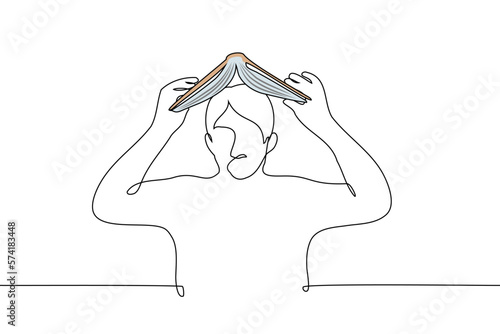 man opened a book above his head - one line drawing vector. concept student wants to absorb knowledge from the book without learning, a desperate ritual to gain knowledge