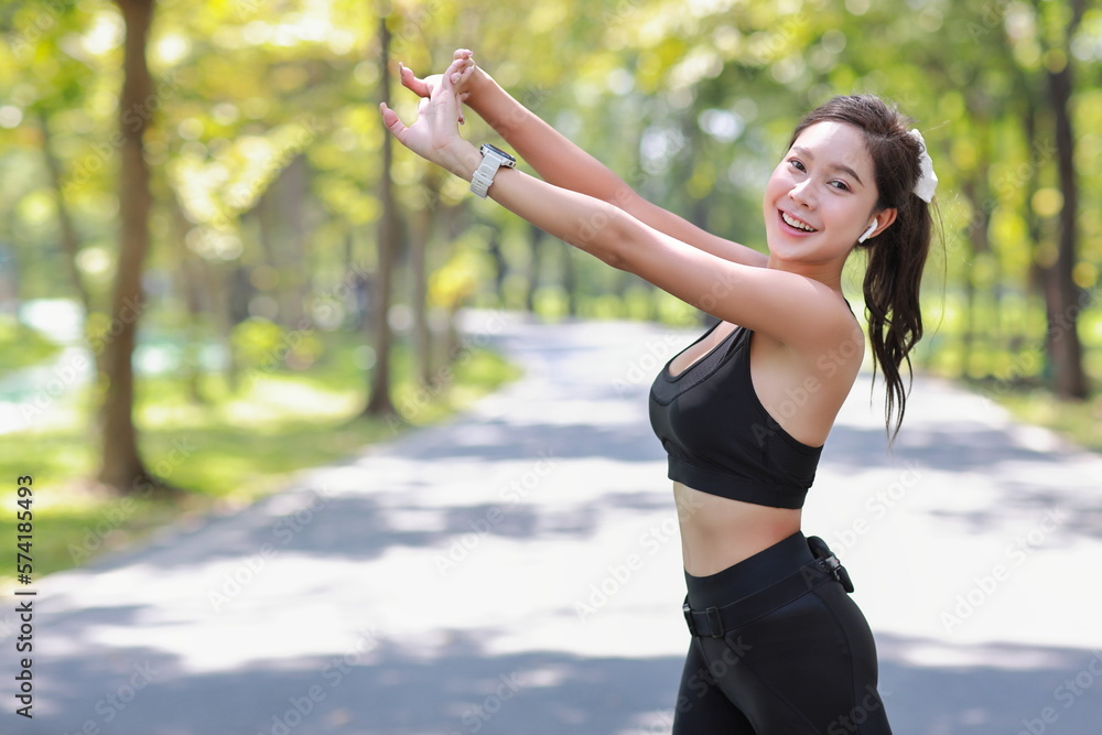 Portrait of happy young asian sportswoman practice yoga stretching and meditation exercise after finish morning run outdoor. Beautiful athlete smile woman listening music under the tree in the park Portrait of happy young asian sportswoman practice yoga stretching and meditation exercise after finish morning run outdoor. Beautiful athlete smile woman listening music under the tree in the park