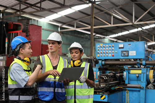 Architect men and worker checking and pointing at heavy industry manufacturing factory with computer. Multiethnic business manager looking in future with warehouse factory building