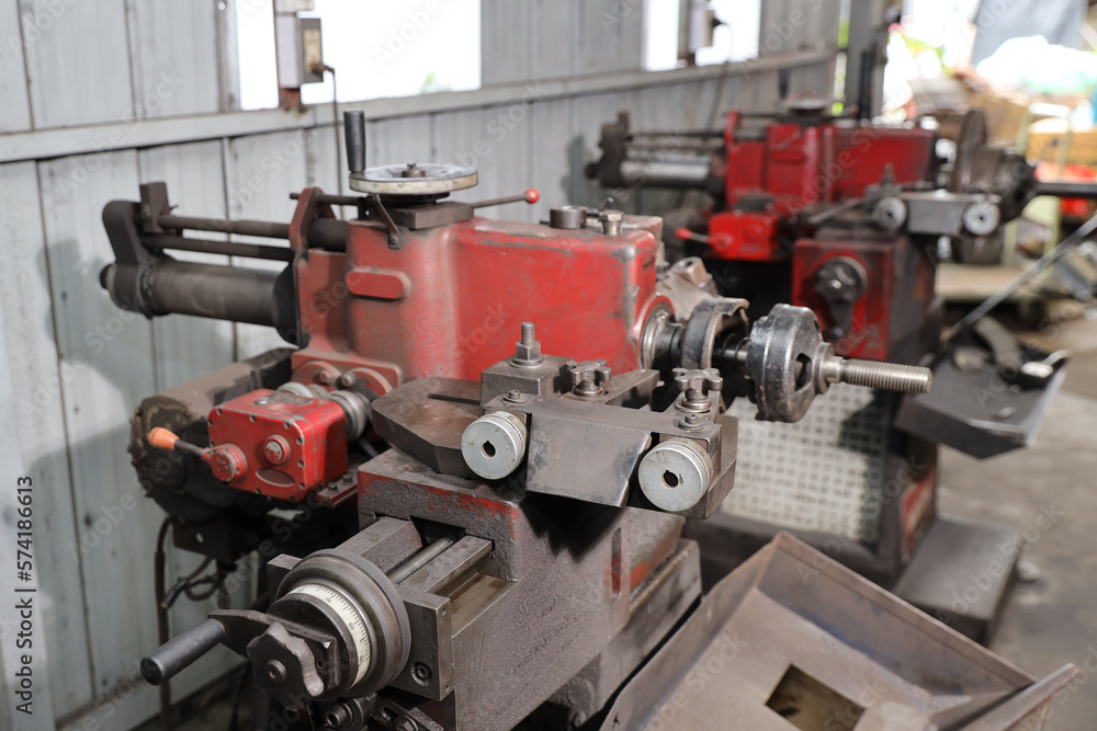 Close up metal lathe machine for polishing car disc brake at garage. Maintenance automotive and inspecting vehicle part concept Close up metal lathe machine for polishing car disc brake at garage. Maintenance automotive and inspecting vehicle part concept