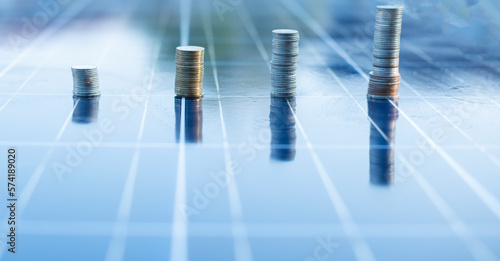 silver coin on solar panel Cells help store solar energy.Then used to produce electricity for homes and buildings to use  reducing costs and preserving the environment.that helps reduce global warming