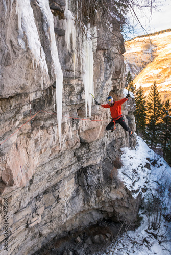 Man jumping off into air for big fall after mixed ice climbing, Colorado, USA photo