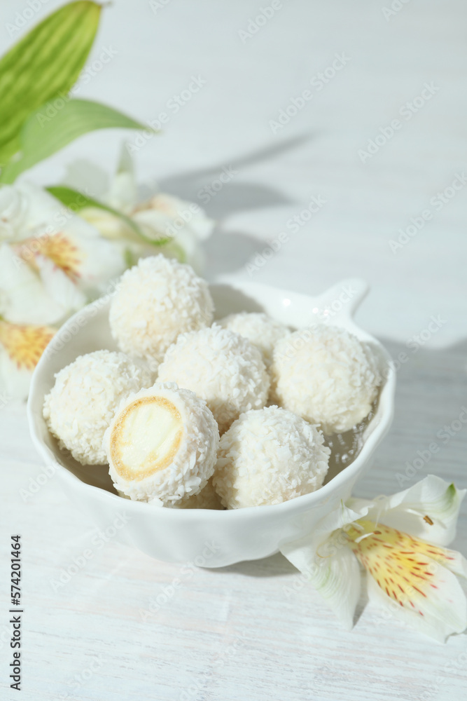 Concept of tasty sweets on white wooden table, coconut candies Concept of tasty sweets on white wooden table, coconut candies