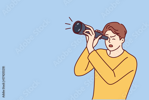 Shocked guy is looking through spyglass while looking at sights or watching rare astronomical phenomenon. Surprised man spying on neighbors using spyglass for uncoordinated surveillance