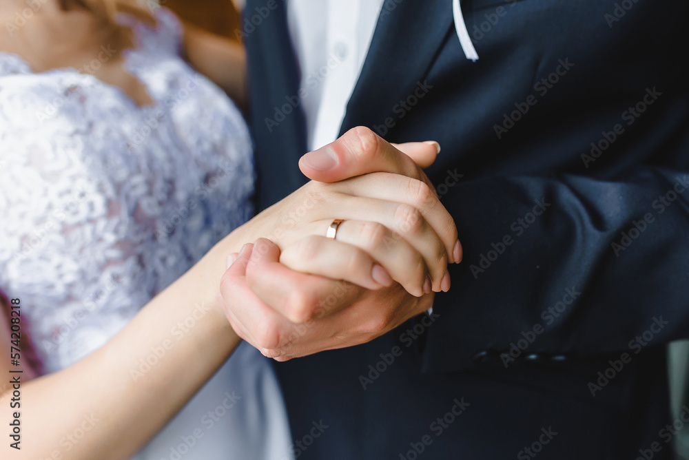 groom holding bride's hand on wedding day