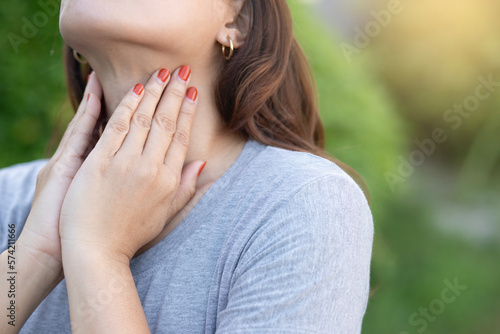 Beautiful young woman touching her sick neck with hands she has neck pain
 Sore throat Difficulty swallowing