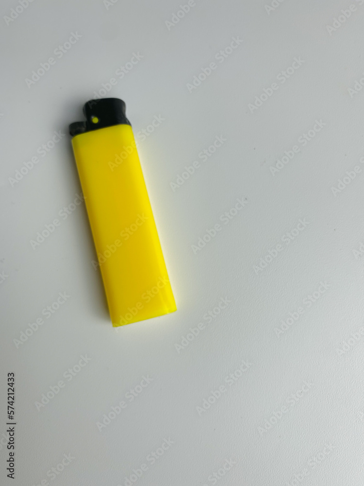 yellow lighter isolated on white background. hand tried to lit yellow lighter. copy space. selected focus yellow lighter isolated on white background. hand tried to lit yellow lighter. copy space. selected focus